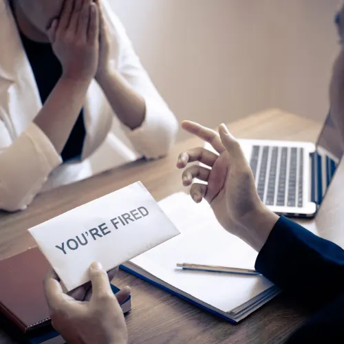 Stressed business woman receive fired letter from employer and packing belongings and files into brown cardboard box, changing and resigning from work concept.